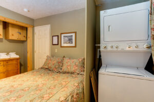 bedroom with queen bed and laundry