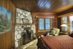 bedroom with queen bed and stone fireplace