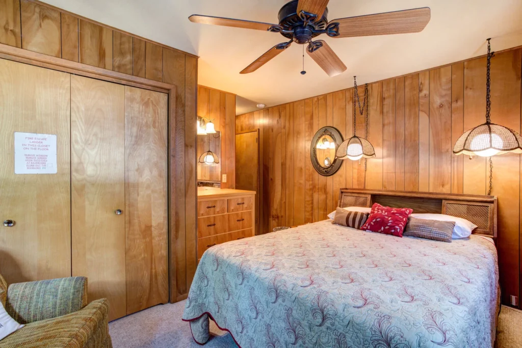 bedroom with wood paneling and queen bed