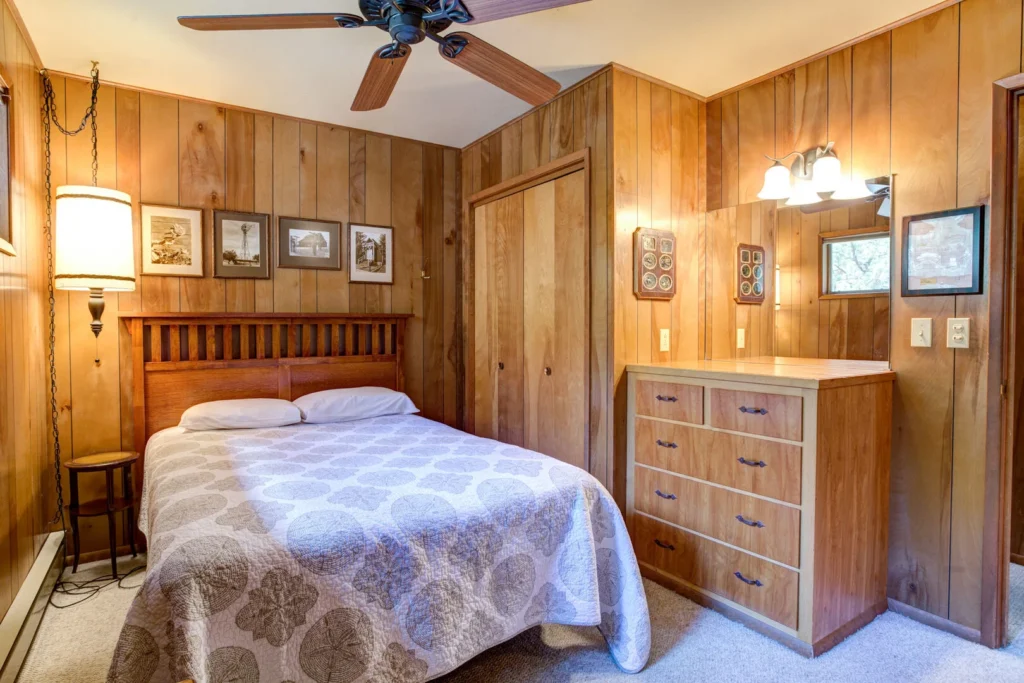 bedroom with wood paneling and queen bed