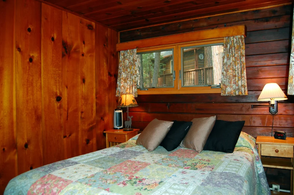 bedroom with window, wood walls, and queen bed