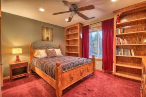 bedroom with queen bed and wood shelving