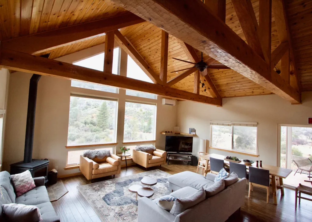 living room with tall ceiling, windows, television and fireplace