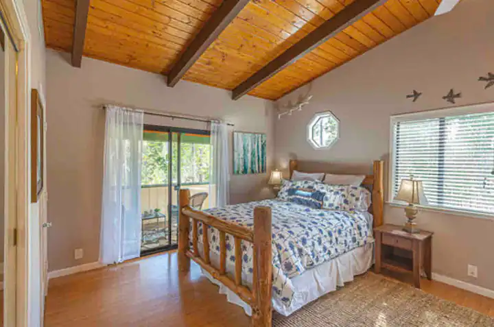 bedroom with beams and carved wooden bed