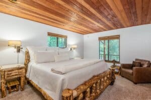 bedroom with carved wood bed frame and wood paneled ceiling
