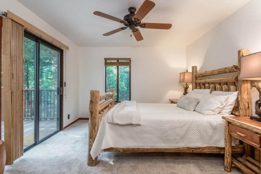 bedroom with doors to balcony, wood carved bed frame