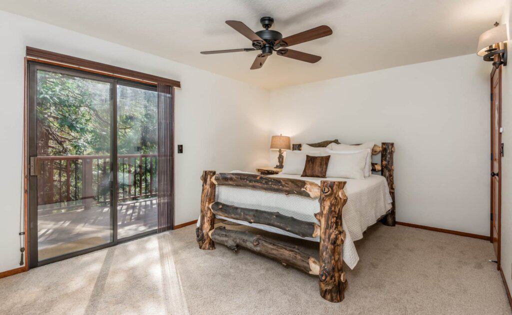 bedroom with wood carved bed frame and balcony doors