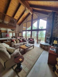 living room with vaulted ceilings, wood stove and seating