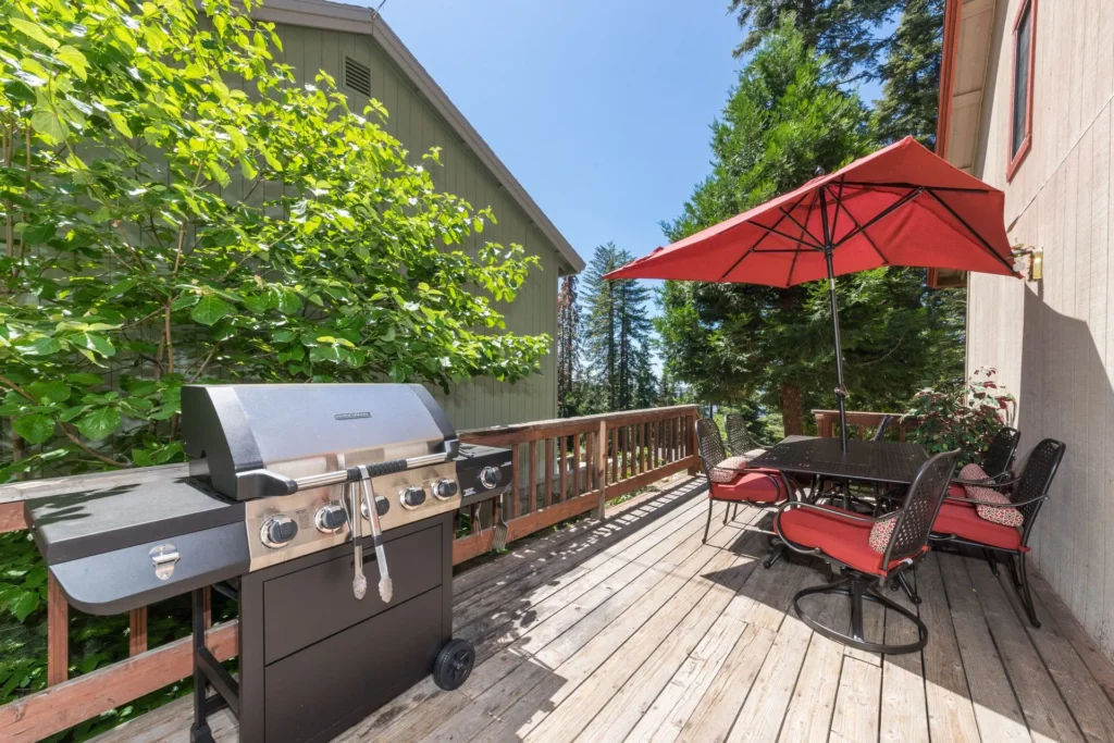 deck with grill and red umbrella dining set