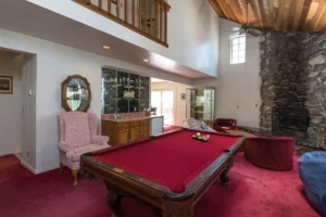living rom with stone fireplace and pool table