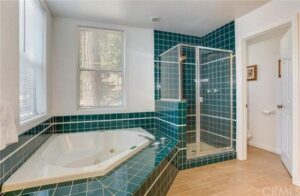 bathroom with spa tub, shower, and teal tiles