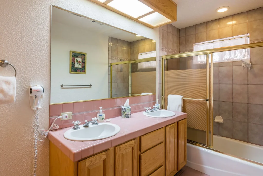 bathroom with his and her sinks and step in tub