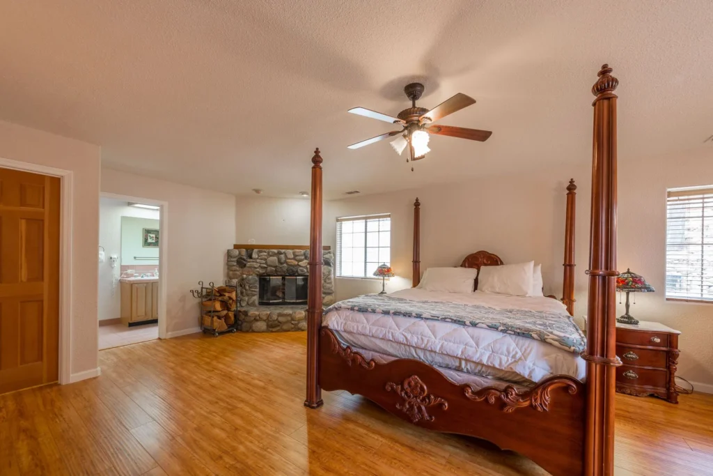 bedroom with four poster bed and fireplace