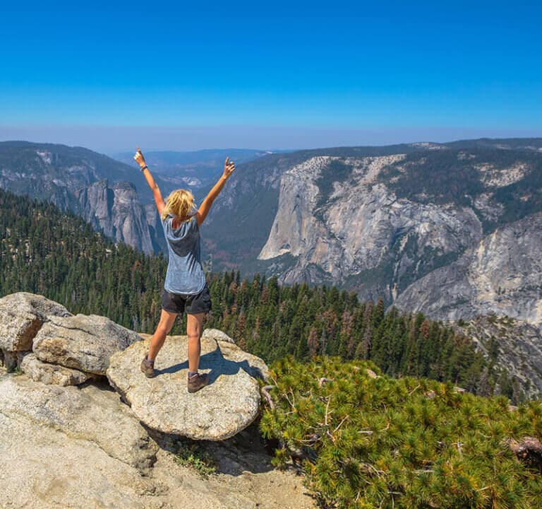 Woman celebrating at view of Yosemite Valley from Sentinel Dome