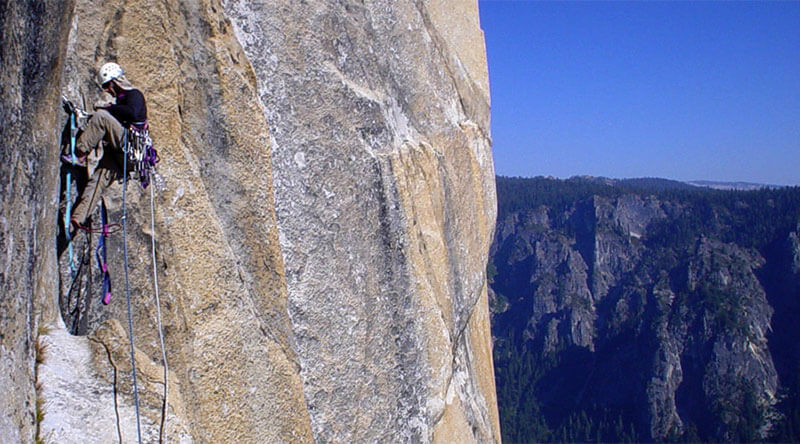 Aid Climbing on The Salathe Wall on El Capitan. You can see the webbing ladders called aiders or etriers used to make upward progress.