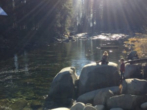 people sitting on rocks overlooking the river