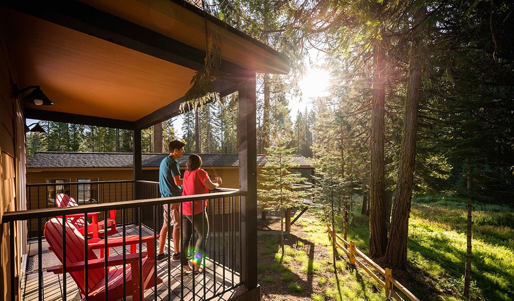 Couple on private deck of an Explorer Cabin at Tenaya Lodge