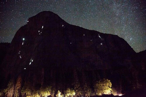 Climbers' headlamps high on El Capitan during the fall rock climbing season.