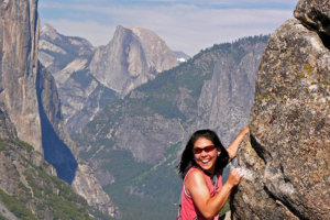 Smiling woman climbing boulders on Turtleback Dome