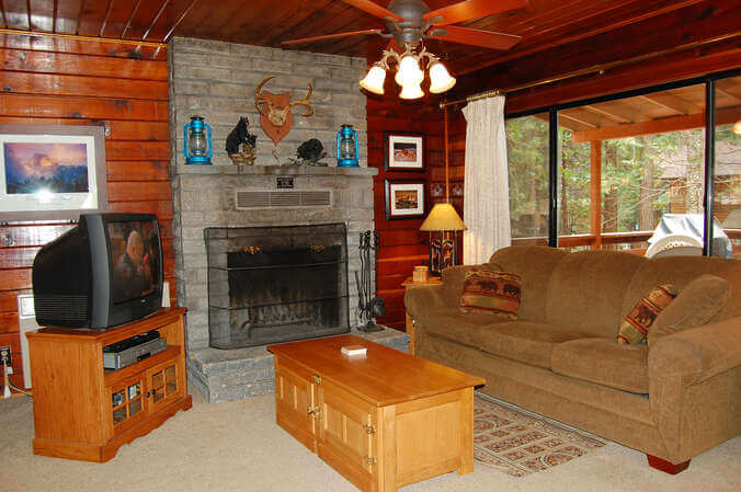living room with stone fireplace, television, and couches