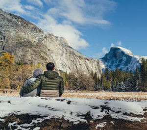 Romantic couple looking at snow-covered Half Dome
