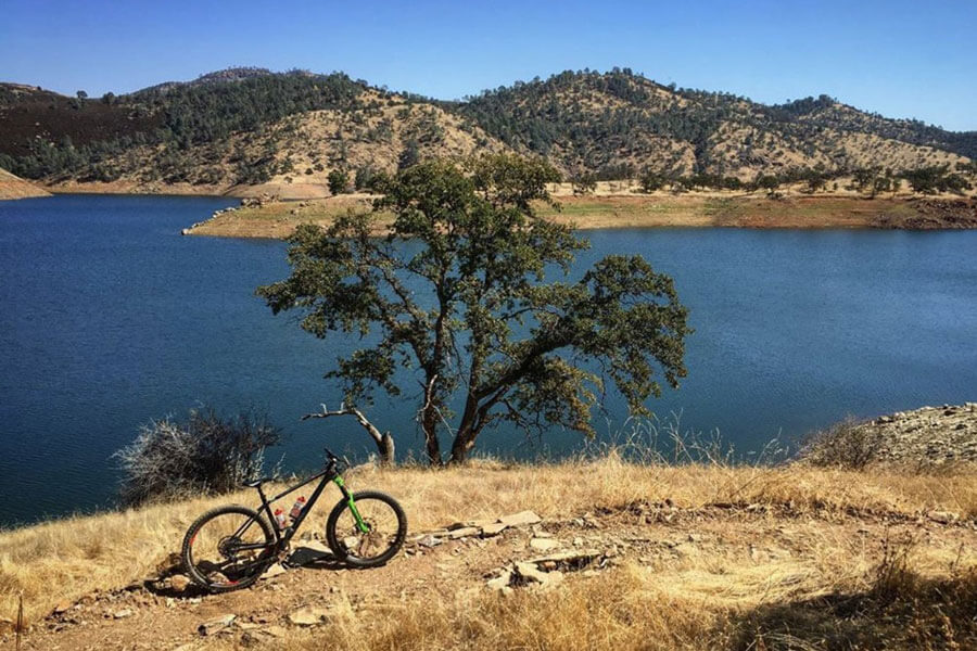 Mountain bike on a trail at Exchequer Mountain Bike Park overlooking Lake McClure