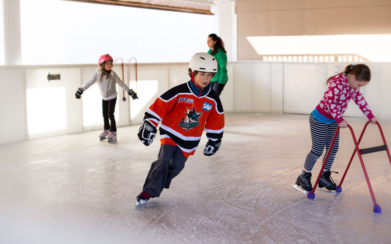 Young hockey player circles the ice skating rink at Tenaya Lodge.