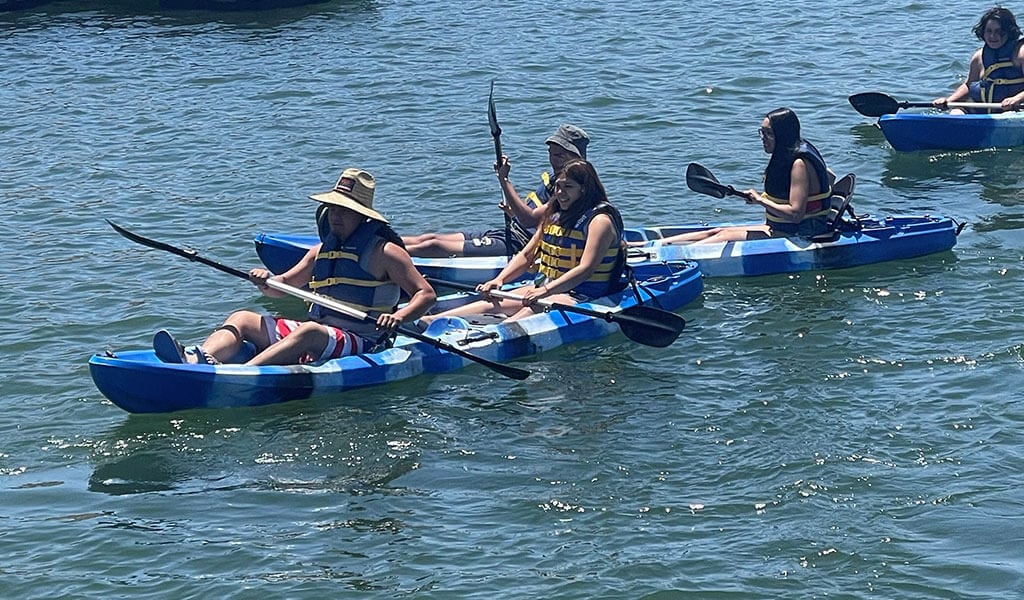 Group of people on open sit-on-top kayaks