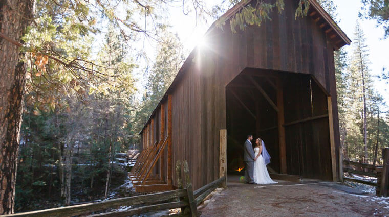 Wedding couple in Wawona's covered bridge