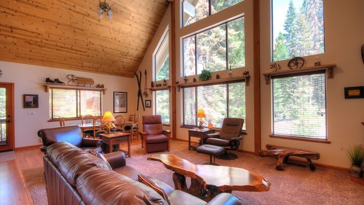 living room with vaulted ceilings and large windows