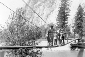 Historic image of a family lined up on the narrow swinging bridge in Yosemite Valley
