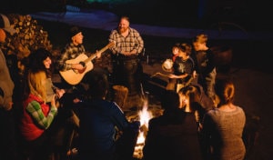 Group enjoying music around a campfire at Yosemite Bug Rustic Mountain Resort