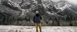 man staring at mountain range in winter