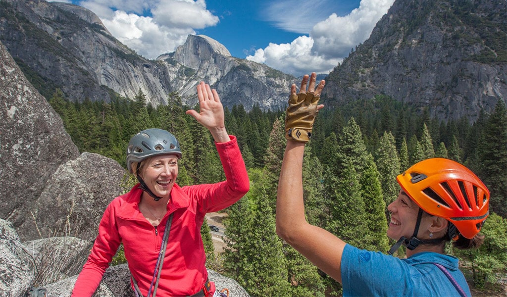 Two women rock climbers giving each other a high-five.