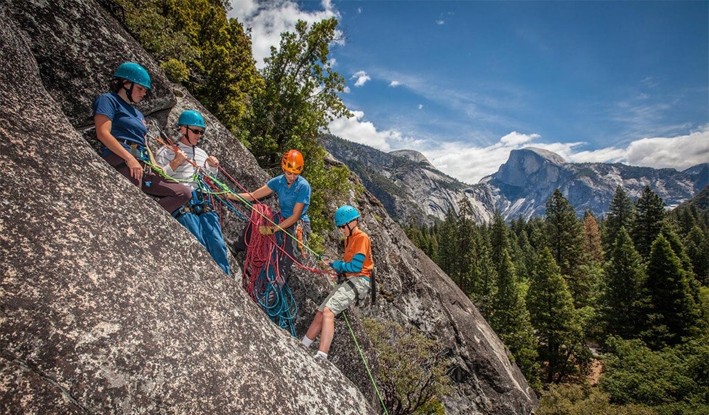 Family climbing Yosemite's rocks with a Yosemite Mountaineering School climbing guide