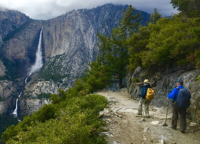 People on a hiking tour in Yosemite with views of Yosemite Falls