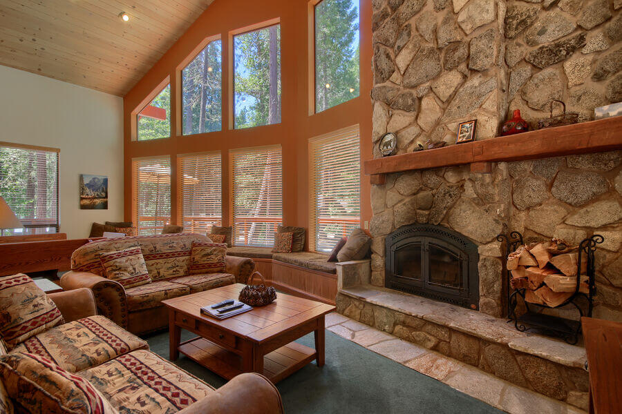 living room with vaulted ceilings and stone fireplace