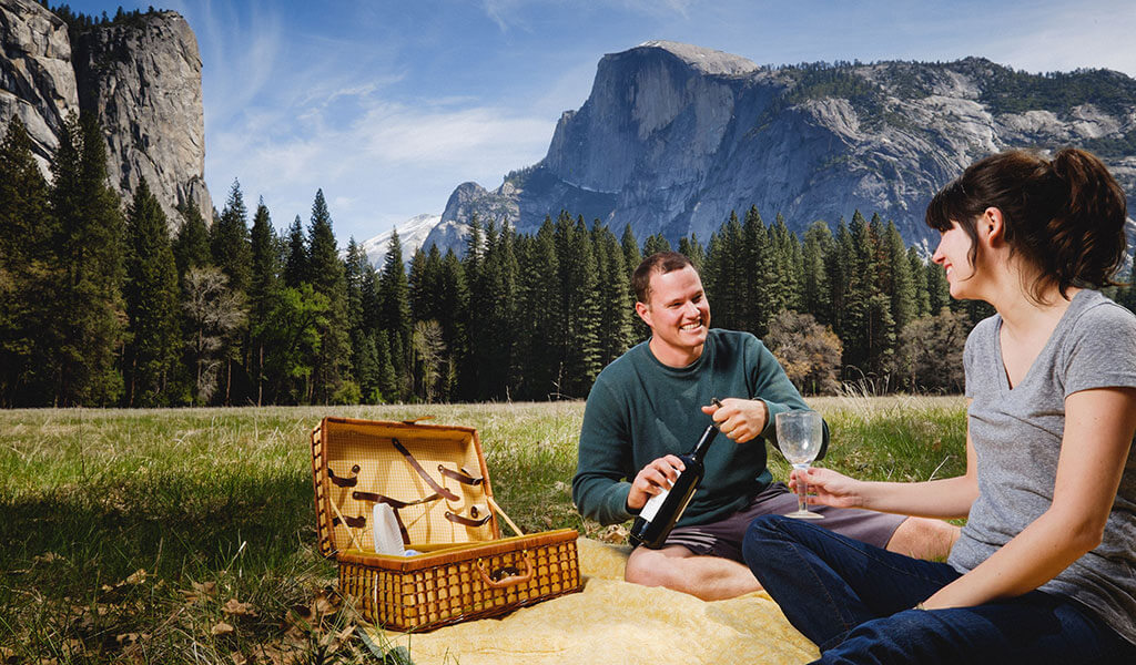 Couple enjoying a picnic with a view of Half Dome behind.
