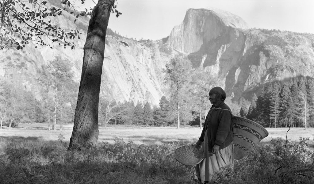 Miwuk woman with baskets in front of Half Dome