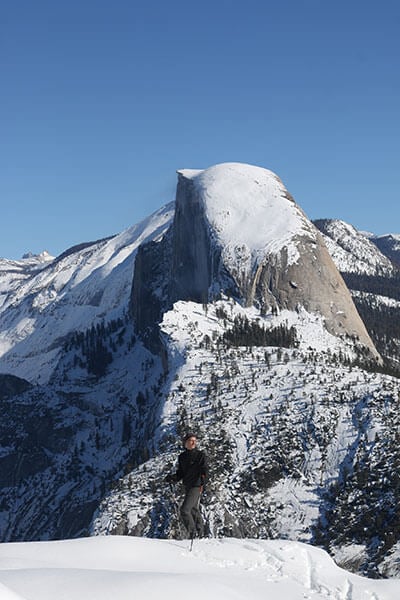 Skier at Washburn Point with Half Dome behind.