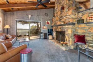 living room with fireplace, television, sectional, and deck access