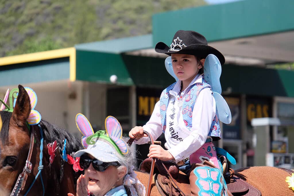 child with butterfly wings riding a horse