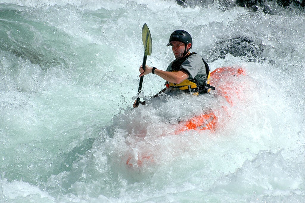 man kayaking whitewater