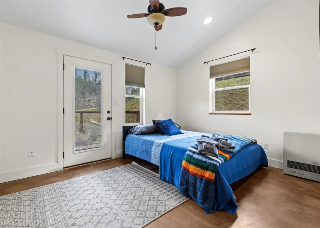 bedroom with queen bed and door to balcony