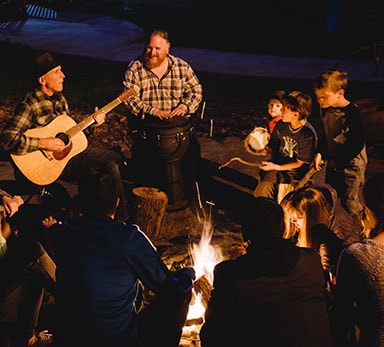 kids sitting around a campfire at yosemite bug rustic mountain resort