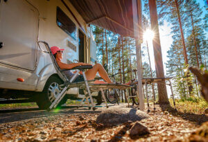 Person relaxing beneath the awning of their RV