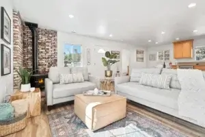 living room with white couches and wood stove