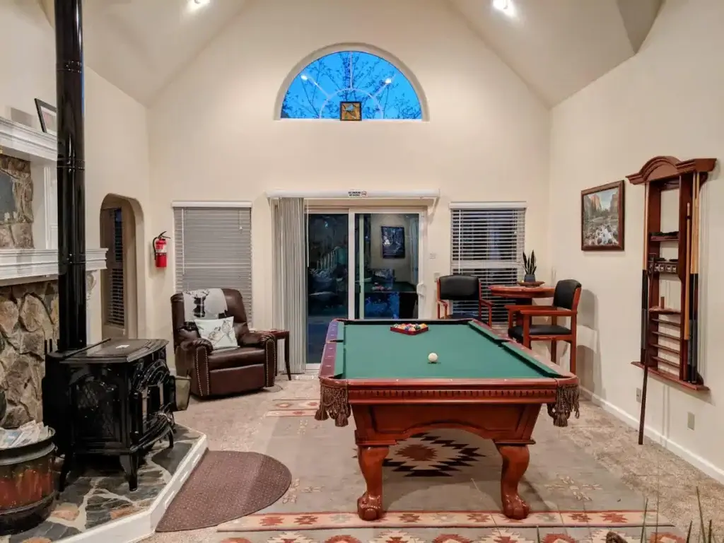 living room with tall ceilings, pool table, and wood stove