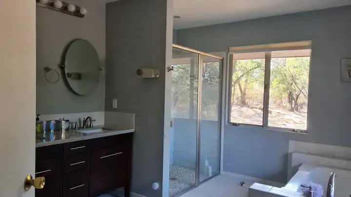 bathroom with walk in shower, vanity, and tub