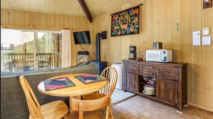 living and dining room with wood stove and television